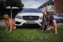 Justin Scrutton, who runs Justin Time Travel in Dartford, pictured with his car, number plate and dogs