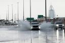 An SUV splashes through standing water on a road in Dubai (Jon Gambrell/AP)