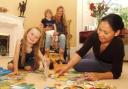 Housekeeper Linda Adsuara plays with Olivia, five while mum Julia and Miles, three, look on