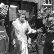 The Duke of Edinburgh helps the Queen alight from the Australia State Coach at the State Opening in 1988 (David Jones/PA)