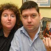 Andrea and Paul Gallagher hold a picture of their son