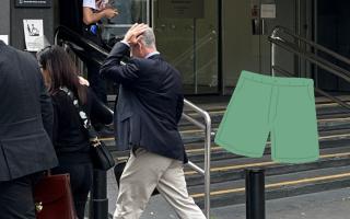 Murphy (right) pictured wearing navy blazer and tan trousers as he covers his face while leaving court