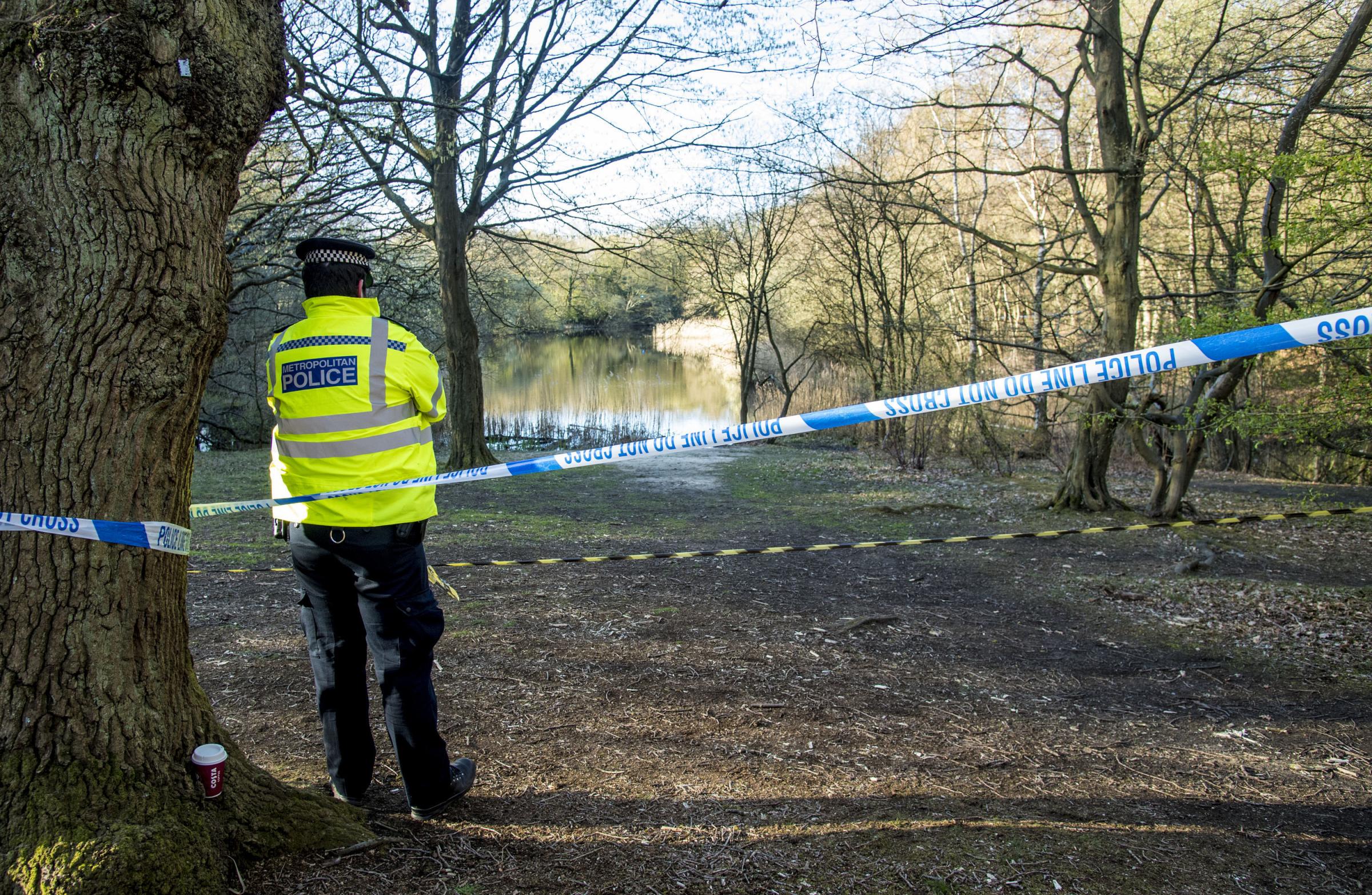 Metropolitan Police officers at the scene at the Wake Valley pond in Epping Forest following the discovery of a mans body. Ian West/PA Wire.