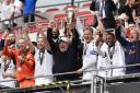 Bromley manager Andy Woodman lifts the play-off final trophy at Wembley