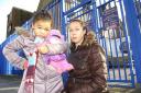 Pearl Louge (right) with her daughter Remi-Leigh, six, outside the gates to Wyborne Primary.