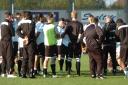 Tony Burman holds a post-mortem with his players on the pitch following the cup exit