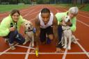 Lewisham's Olympian James Ellington races guide dog puppies Yvonne and Ushi at Ladywell Arena.