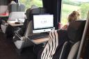 The woman pictured on the train with her desktop computer. Picture: David Hill via Twitter