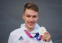Cyclist Ethan Hayter holds his Olympic silver medal at a homecoming party at Herne Hill Velodrome in south London - PA