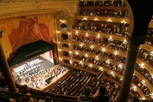 News Shopper: A grand theatre with people watching an orchestra. Credit: Canva