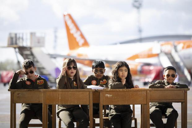 News Shopper: Sam Bennett, aged 12, Olivia Joohee-Riddington, aged 9, Arjun Giri, aged 9, Rei Diec, aged 7 and Rico Jeerasinghe, aged 9 during filming of a parody of the movie Top Gun at Luton airport as part of easyJet's nextGen recruitment campaign. Credit: PA/easyJet