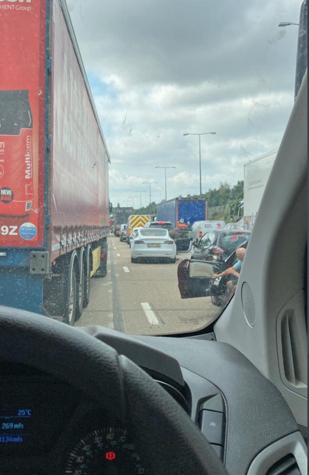 News Shopper: Traffic on the M25 as a group of protestors from Just Stop Oil have climbed motorway signs in response to the extreme temperatures in the UK and what they describe as the Government's "inadequate preparations" for climate change (photo: @Bangers173/ Twitter)