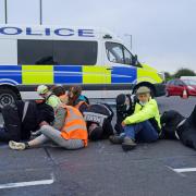 Police officers work to free protesters who had glued themselves to the highway at a slip road at Junction 4 of the A1(M), near Hatfield, where climate activists carried out a further action after demonstrations which took place last week (photo: PA)