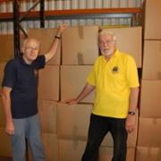 Keith Nixon, (Secretary Biggin Hill & Westerham Lions Club) and Chris Iles (District Shoebox Officer) at central Warehouse with some of the goods that have been packaged, weighed, valued and documented in readiness for shipment.