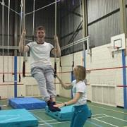 Trapeze instructor Amanda Miles teaches Matthew Jenkin the ropes