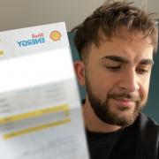 Reporter Berk holding up his new increased energy bill (NS)