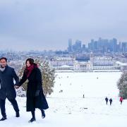 A couple walk through snow in Greenwich Park, south-east London.