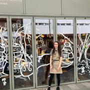 Charli Bull paints Pizza Express windows in Eltham