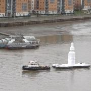 The large white bottle, which turned out to be a The Ordinary skincare advert, was seen being pulled along by a boat near the Thames Barrier earlier today (February 13)