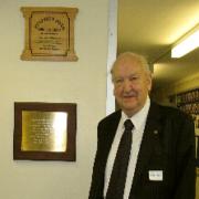 Mr Ellerby beside the plaque commemorating the opening of the school.