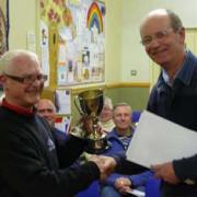 Spring Park chairman Graham Evans hands over a cup won at a film festival in Guildford