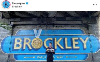 Alex Yee poses with his Brockley gold medal mural (photo: Alex Yee/ Instagram @lixsanyee)